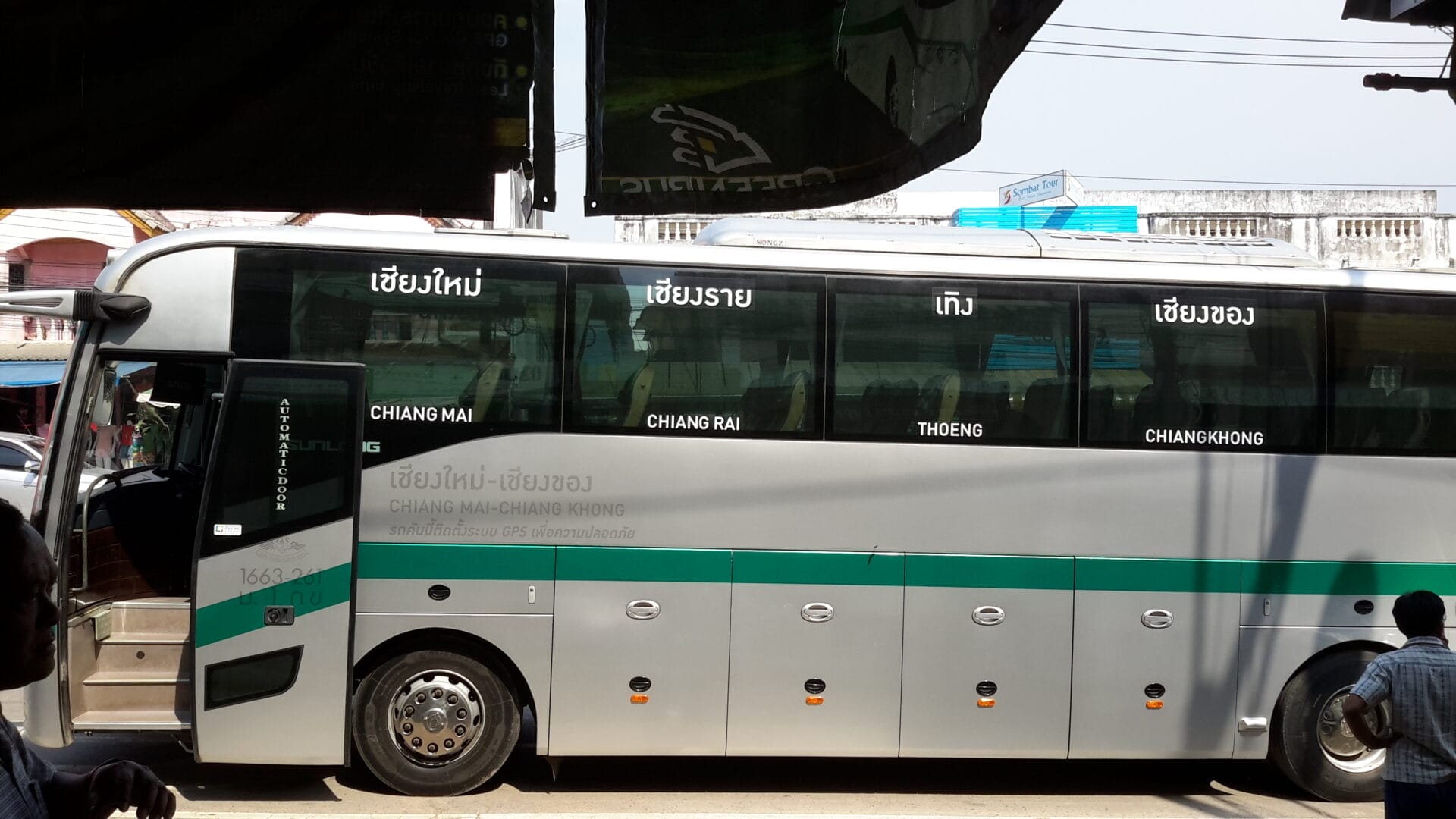 A bus at a station in Chiang Khong, Thailand, with the route listed on the side: Chiang Mai, Chiang Rai, Thoeng, and Chiang Khong.