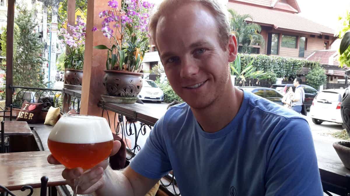 Person holding a glass of beer at a café in Chiang Mai, Thailand.