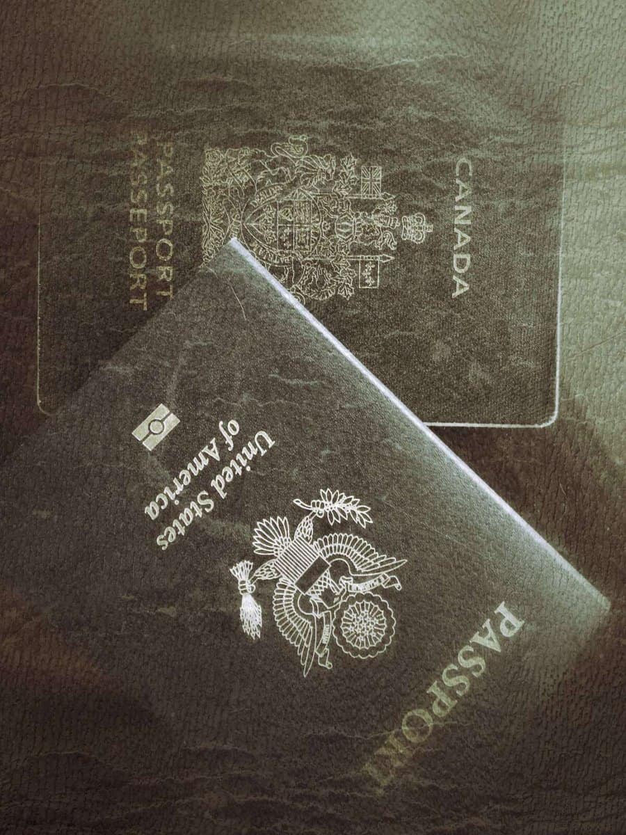 A close-up shot of a United States passport placed on top of a Canadian passport.