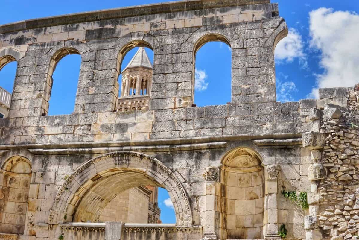 Top City To visit in Croatia with kids-Split Ancient stone wall with archways and a bell tower in the background in Split, Croatia.