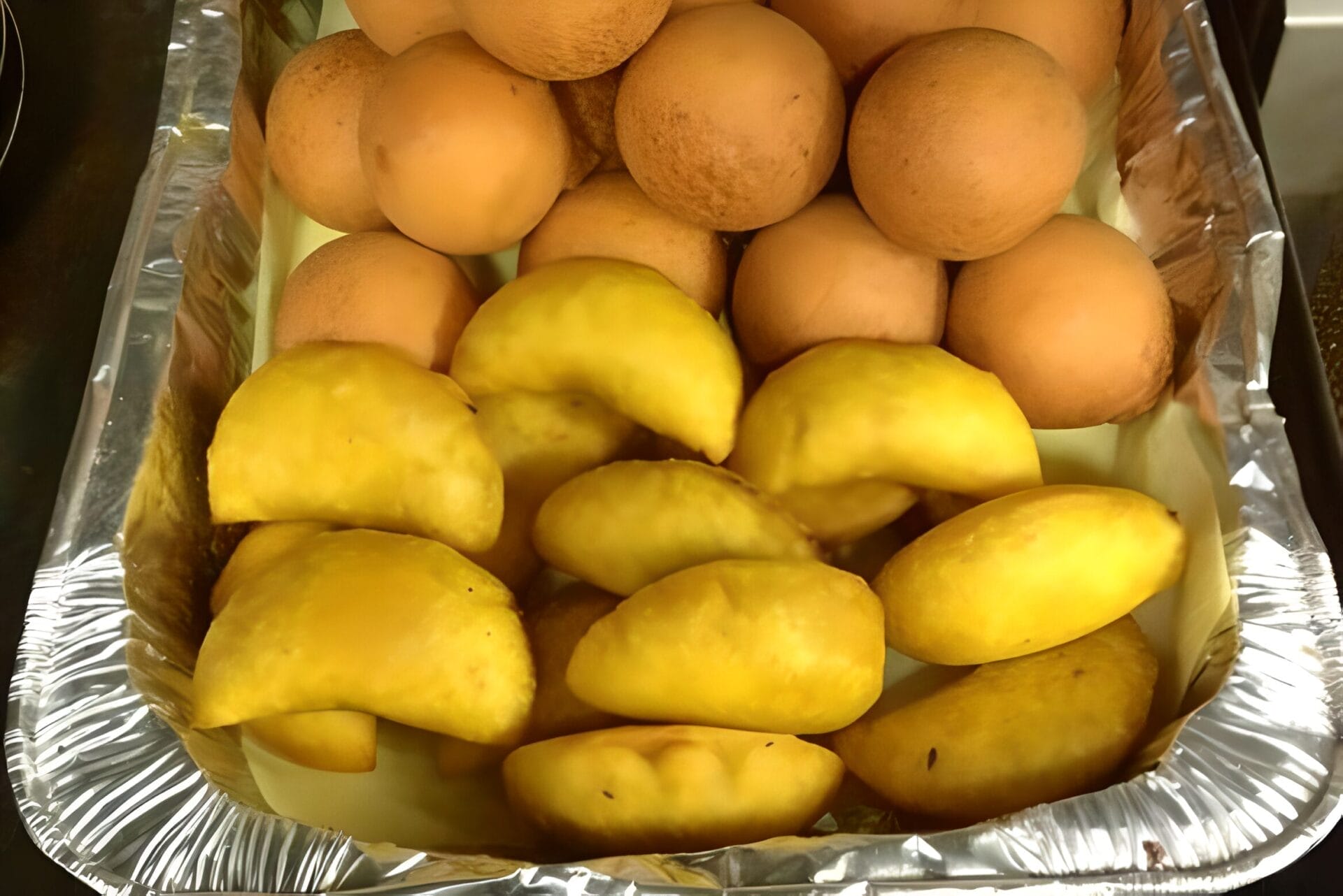 A tray of fresh empanadas and small round buns in Sabaneta neighborhood, Medellin, Colombia.