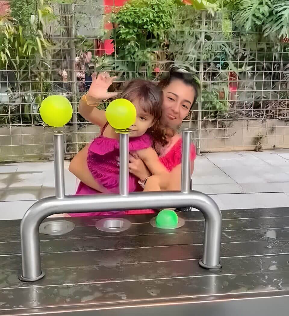 A woman and a child interacting with a science exhibit involving floating balls at Parque Explora in Medellin, Colombia.