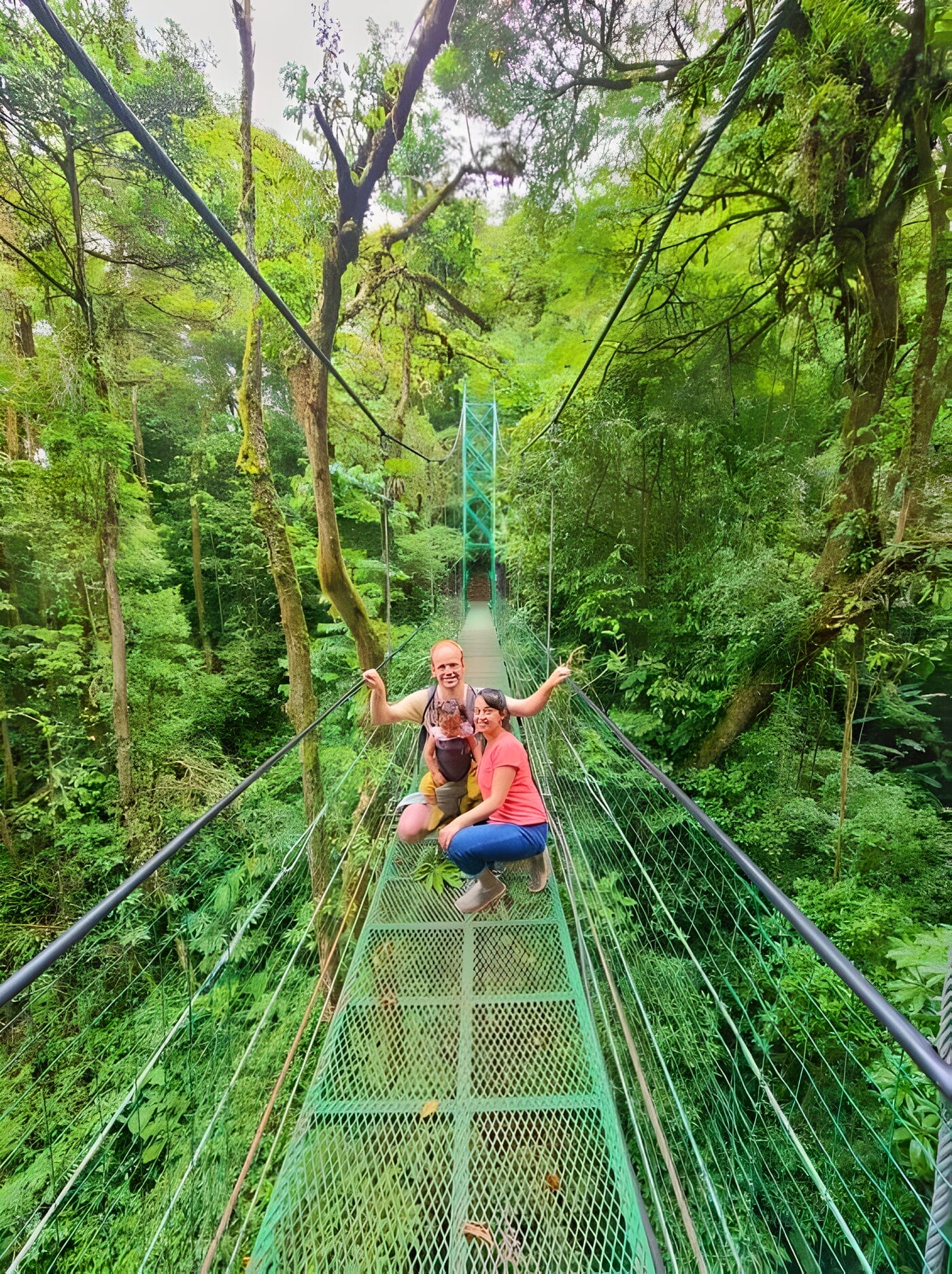 Sky Ventures Hanging Bridges - Monteverde Itinerary A couple poses on the Sky Walk suspension bridge surrounded by lush green forest in Treetopia Park, Monteverde, Costa Rica.