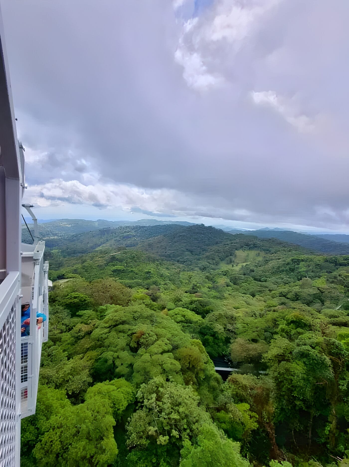 Skytrek - Sky Ventures Monteverde Activity A scenic view of lush green forests and rolling hills from the Sky Tram in Treetopia Park, Monteverde, Costa Rica, under a cloudy sky.