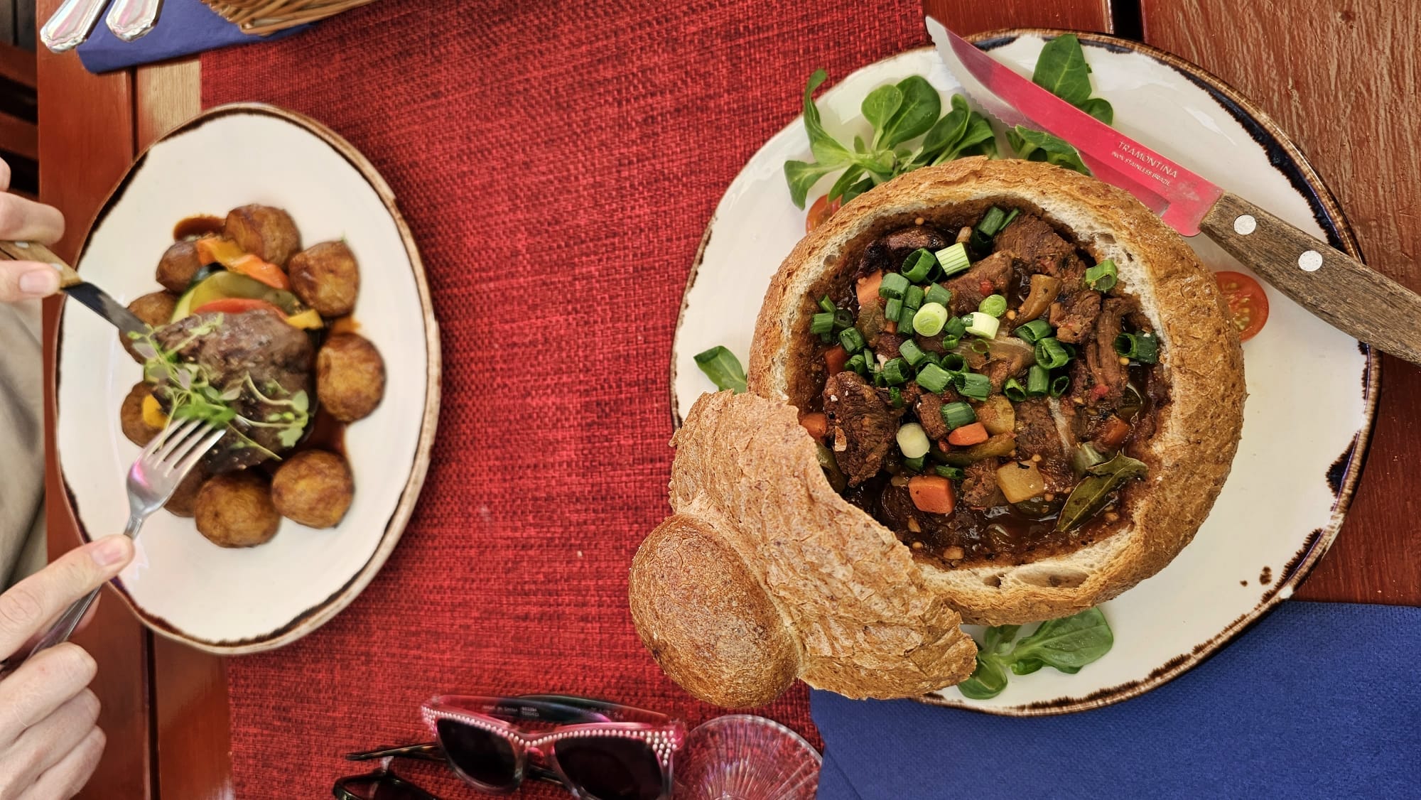 Traditional Estonian meal served in a bread bowl and a dish of potatoes with meat at a restaurant in Tallinn, Estonia.