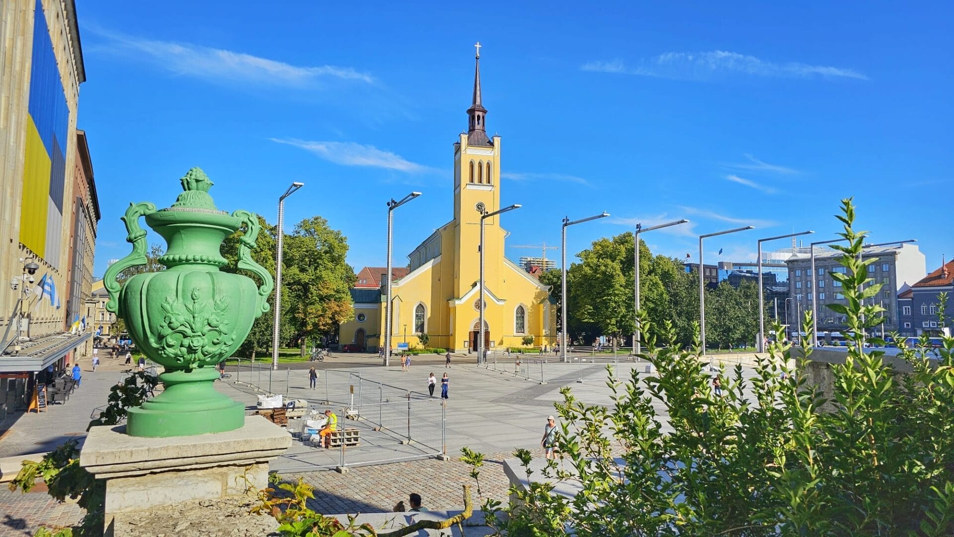 A view of St. John's Church in Tallinn, Estonia with a prominent green urn in the foreground and a blue sky backdrop.