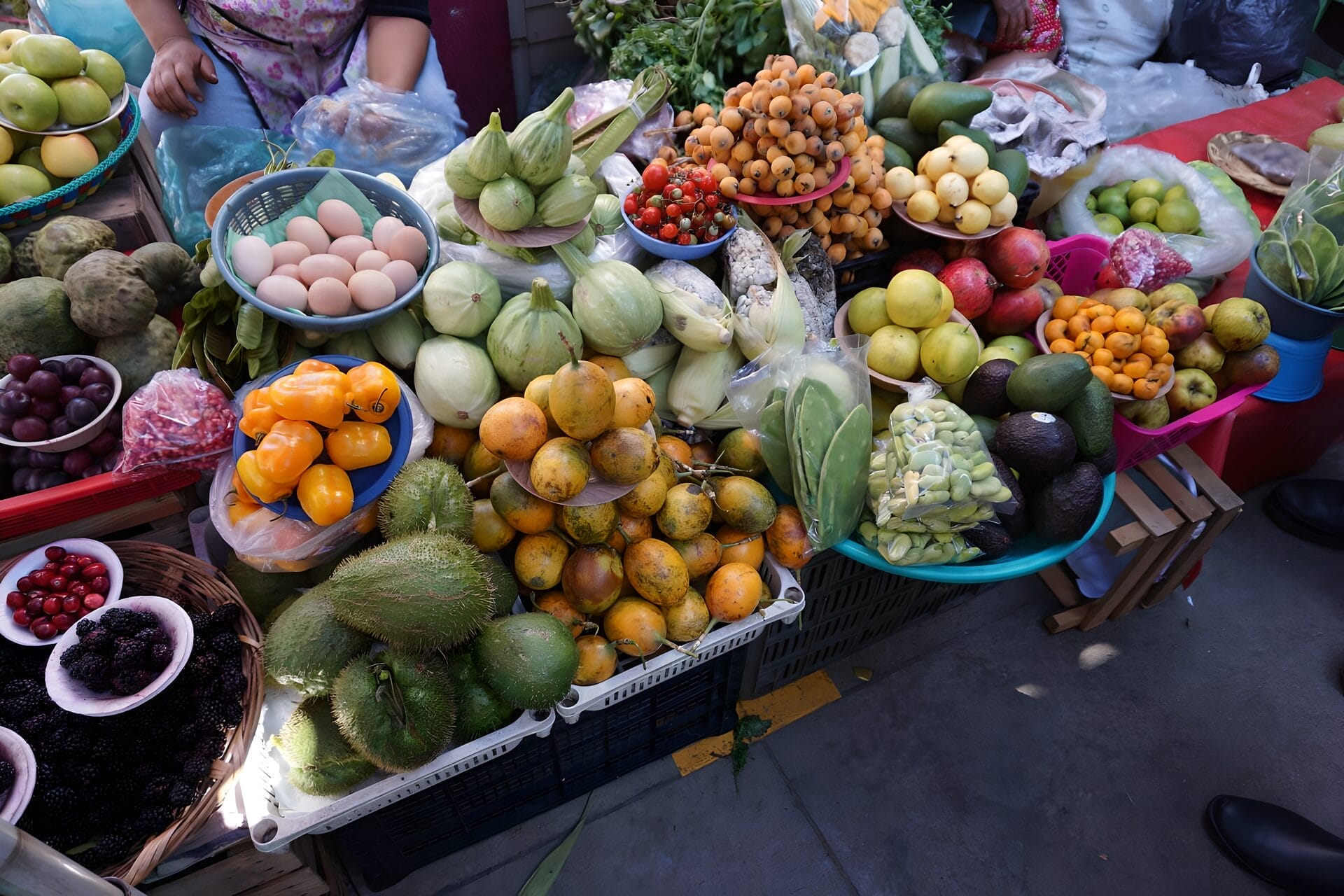 A diverse display of fresh fruits and vegetables at a vendor's stall in Benito Juarez Market, Oaxaca City, Mexico. 