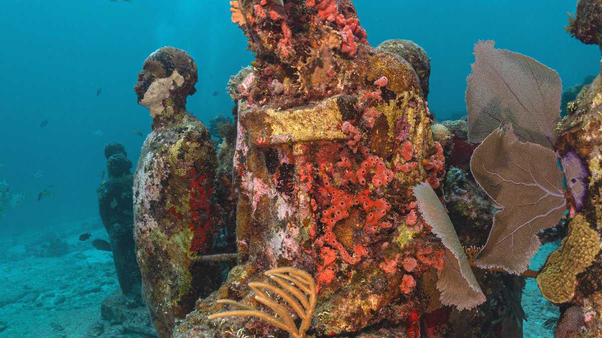 Underwater statues with coral growths at Museo Subacuático in Isla Mujeres, Quintana Roo, Mexico.