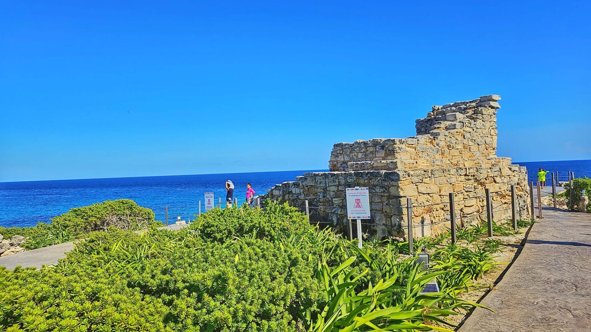 Ancient Mayan ruins on a clear day with a bright blue sky and the Caribbean Sea in the background at Isla Mujeres, Quintana Roo, Mexico.