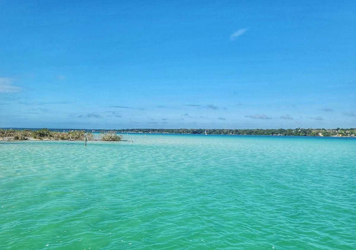 Scenic view of Bacalar Lagoon with turquoise water under a clear blue sky in Bacalar, Quintana Roo, Mexico.
