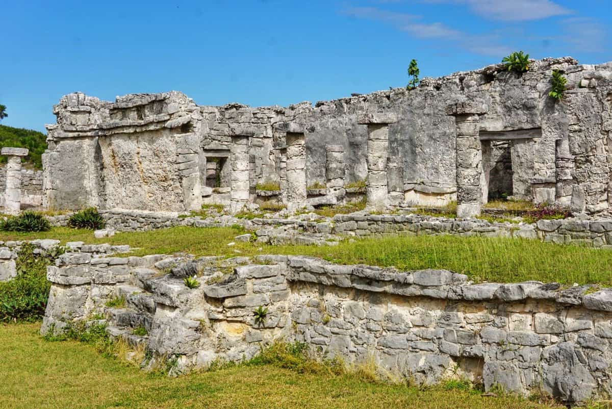 Ancient stone structures at the Tulum Ruins in Mexico under a clear blue sky.