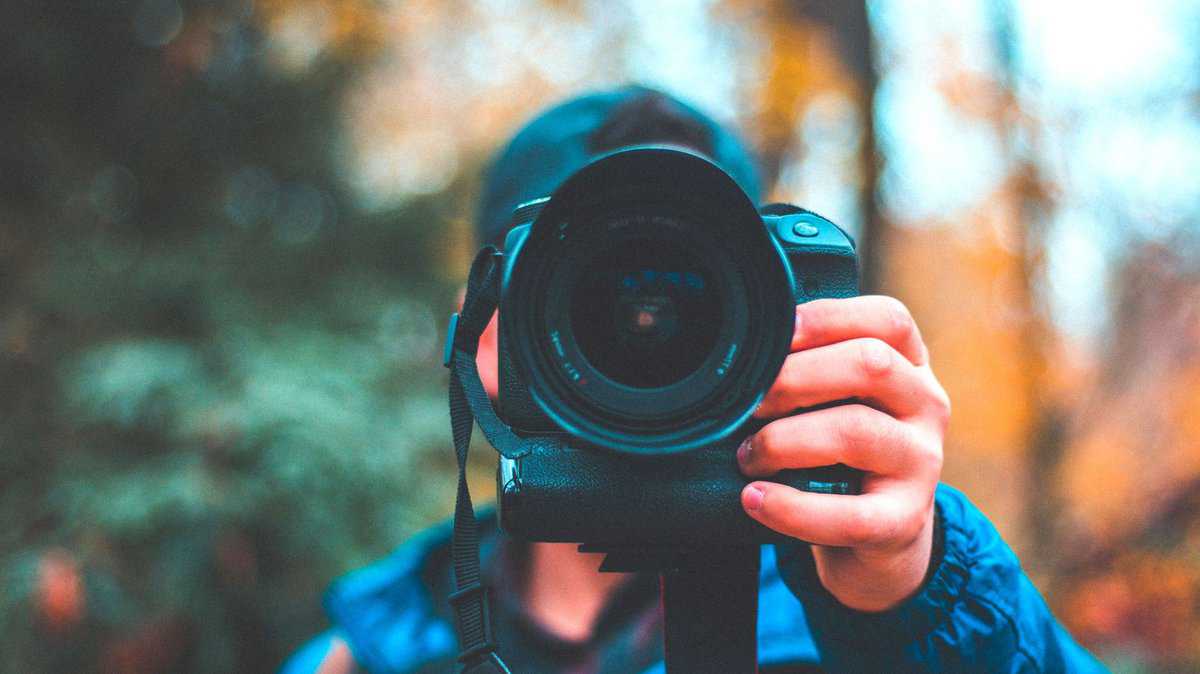 Person holding a camera taking a photo in Yosemite National Park.