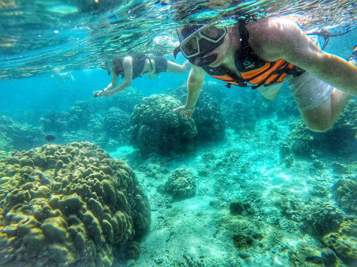 Two snorkelers exploring coral reefs underwater in Koh Lanta, Thailand.