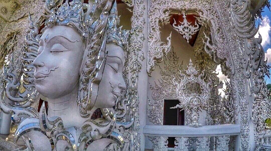 Close-up view of ornately detailed sculptures at the White Temple (Wat Rong Khun) in Chiang Rai, Thailand.