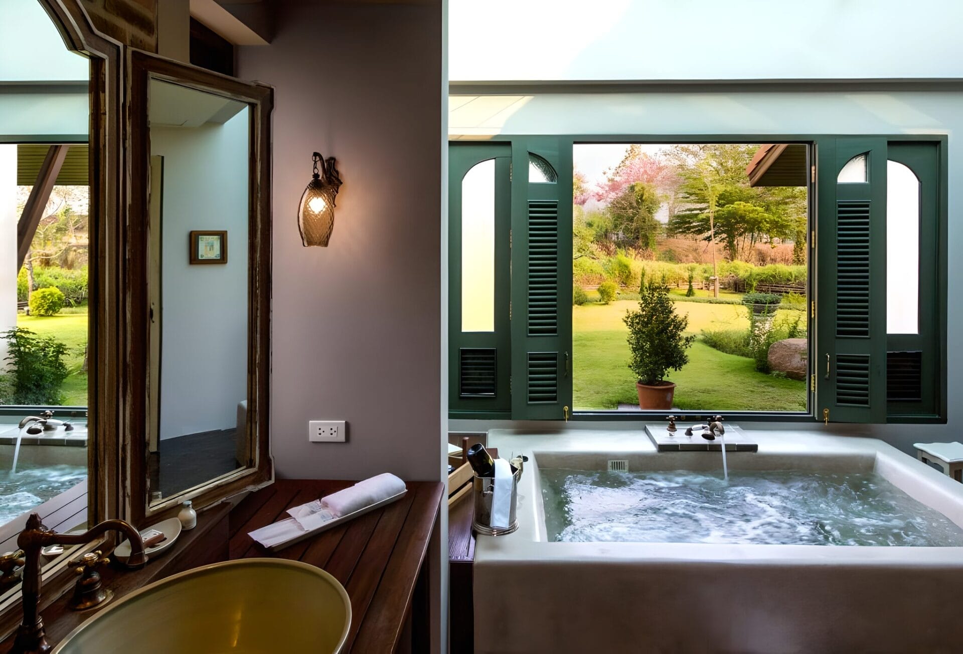 Luxurious bathroom in Reverie Siam Resort with a view of the lush garden through open windows in Pai, Thailand.